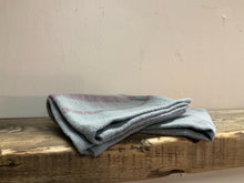 Load image into Gallery viewer, Folded image of woven cotton blend tea towels gray/purple in a wooden table
